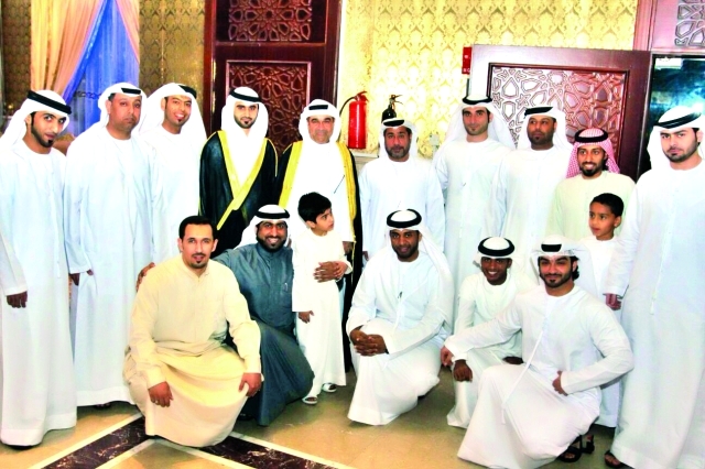 "العريس ووالده يتوسطان الأهل والأصدقاء"