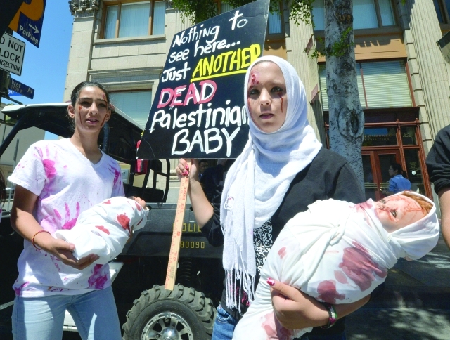 "فلسطينيون يحملون دمى الرضع ملطخة بالدماء خلال مسيرة احتجاجية في لوس أنجلوس ضد العدوان على غزة رويترز"