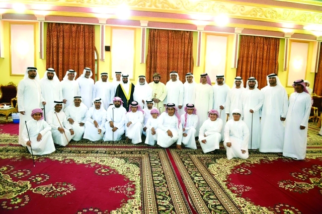 "العريس ووالده يتوسطان عدداً من الأهل والأصدقاء"