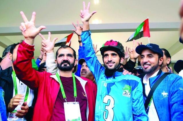 "محمد بن راشد وحمدان بن محمد يرفعان شارة النصر والفوز والحب بعد التتويج باللقب\tتصوير - خليفة اليوسف"