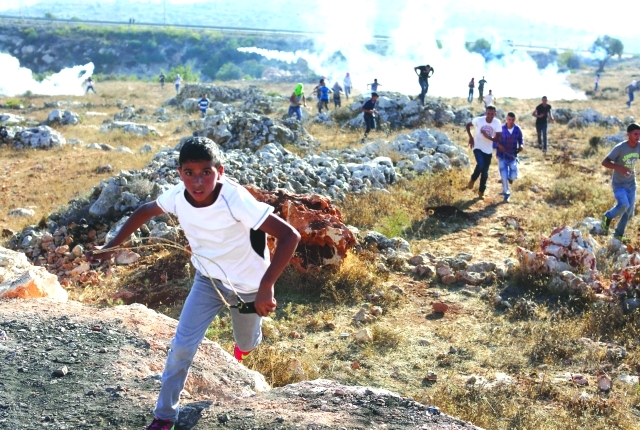 "فلسطينيون يهربون من قنابل الغاز التي أطلقها جيش الاحتلال على المتظاهرين في بلدة سلواد \tأ.ف.ب"
