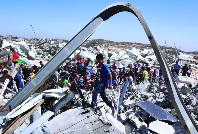 "طلبة فلسطينيون يشاركون في تظاهرة على أنقاض مصنع ألبان هدمته سلطات الاحتلال في الخليل بالضفة الغربية     أ.ف.ب"