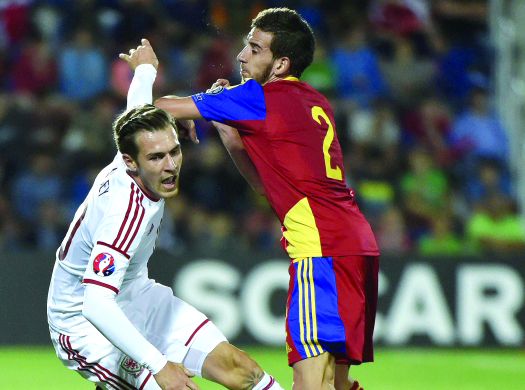 "Andorra defender Cristian Martinez (R) vies with Wales forward Aaron Ramsey during the Euro 2016 qualifying round football match Andorra vs Wales on September 9, 2014 at the Municipal Stadium in Andorra. AFP PHOTO / PASCAL PAVANI"