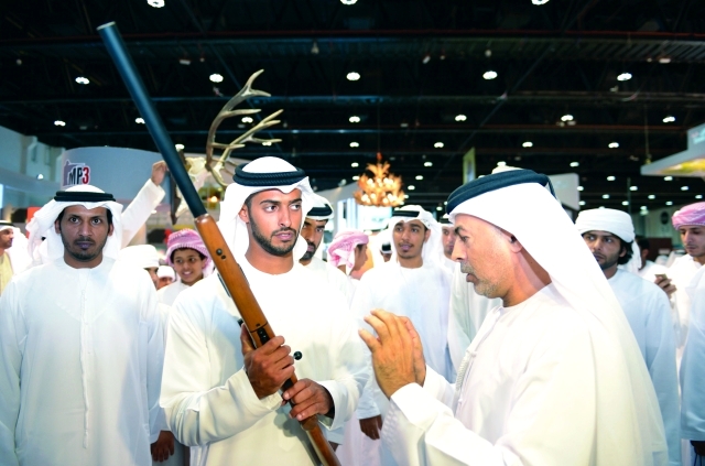 "زايد بن حمدان بن زايد يستمع إلى شرح عن أحد الأسلحة المعروضة وام"