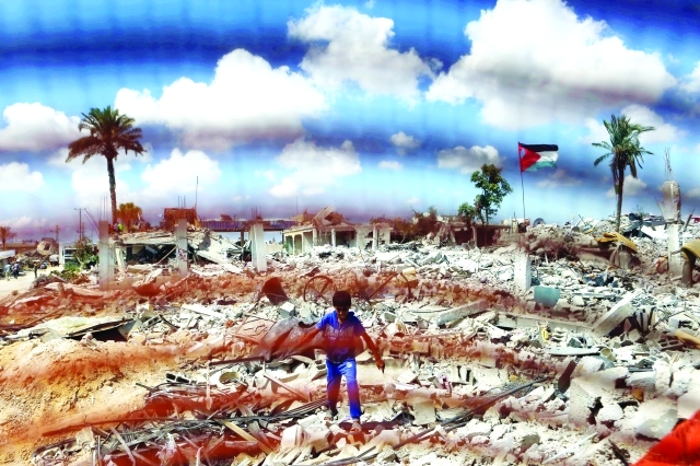 "طفل فلسطيني يمشي على أنقاض منازل مدمرة في خانيونس بسبب العدوان الإسرائيلي على قطاع غزة \t أ.ف.ب"