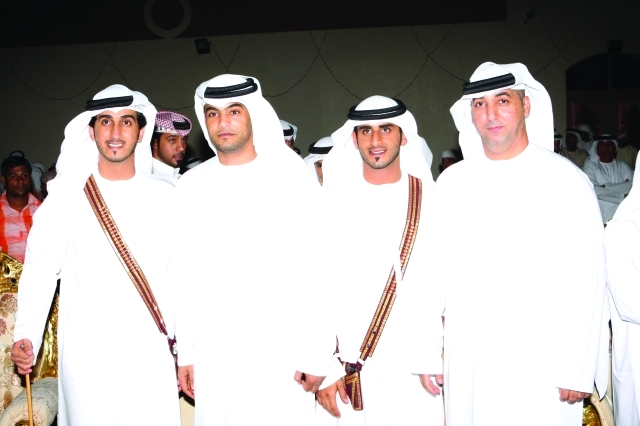 "العريسان عبدالله وراشد مع أحد الأهالي"