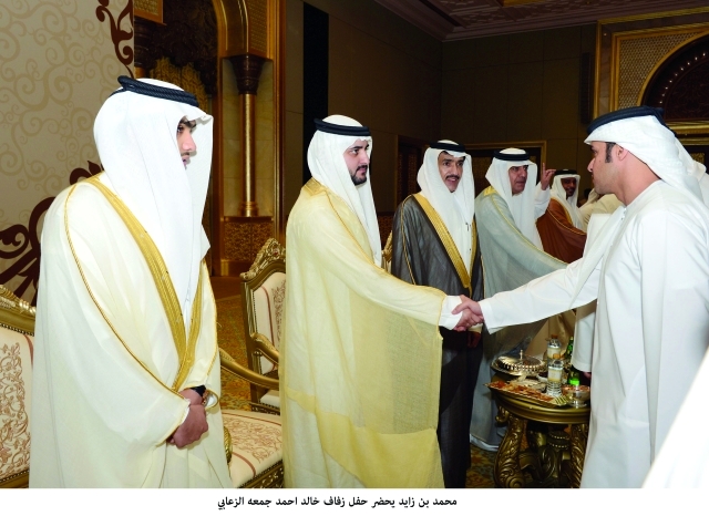 "مكتوم بن محمد يصافح الحضور وإلى جانبه أحمد الزعابي ونجله خالد"