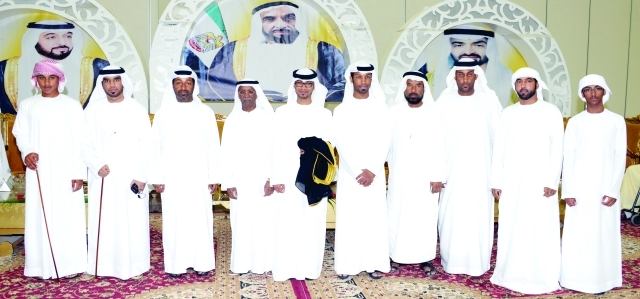 "العريس يتوسط عدداً من الأهل والأقارب"