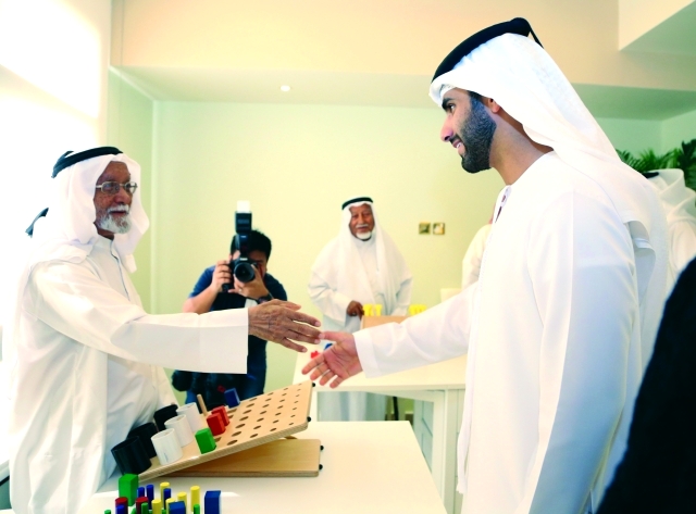 "منصور بن محمد يصافح كبار السن في النادي"