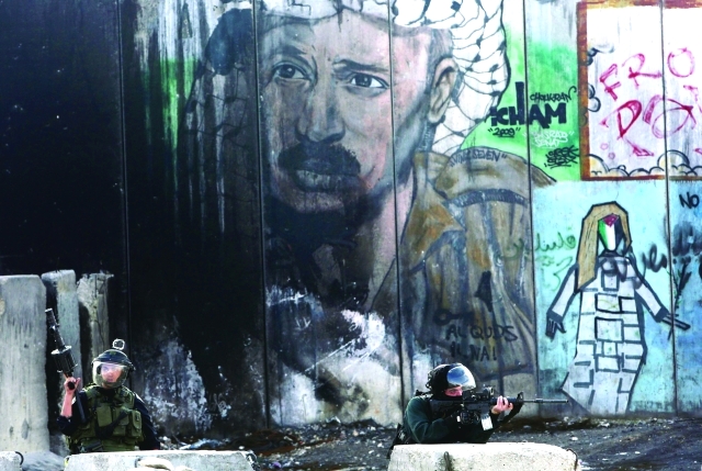 "جنديان إسرائيلييان يطلقان الغاز المسيل على المتظاهرين قرب جدار الفصل - رويترز"