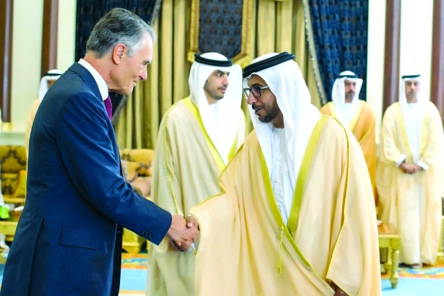 "ويصافح بحضور حامد وعمر بن زايد أحد الضيوف"
