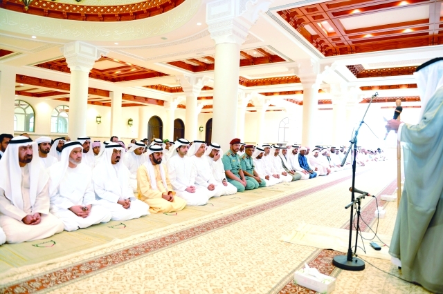 "طحنون بن محمد وهزاع بن طحنون والمسؤولون يؤدون الصلاة ــ وام"