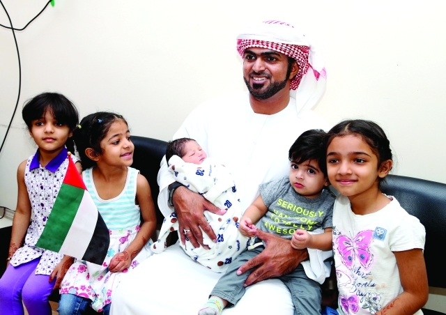 "علي الشحي يحمل محمد وبجواره أطفال الأسرة"
