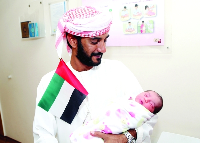 "حسن الشحي يحمل مولودته فاطمة ــ \t تصوير- محمد حنيف"