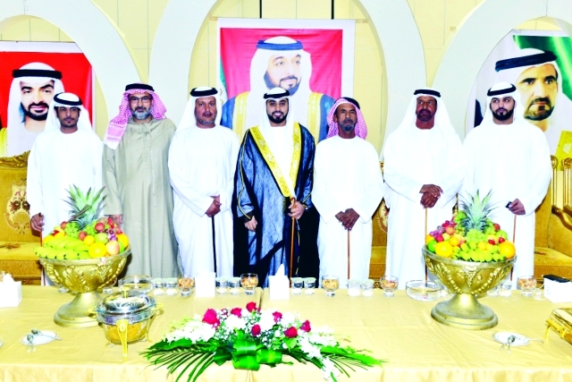 "العريس يتوسط والده وأقاربه"