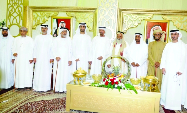"أحمد خليفة السويدي يتوسط العريس محمد عبدالله الدويس الشامسي وعدداً من الحضور"