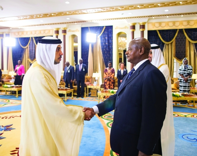 "الرئيس الأوغندي يصافح منصور بن زايد"