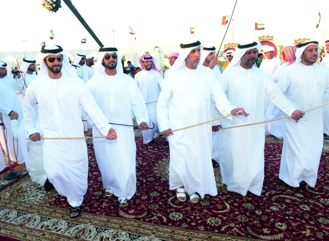 "العريسان يشاركان في رقصة شعبية"