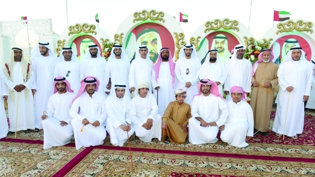 "العريسان ووالدهما يتوسطون الأهل والأصدقاء"