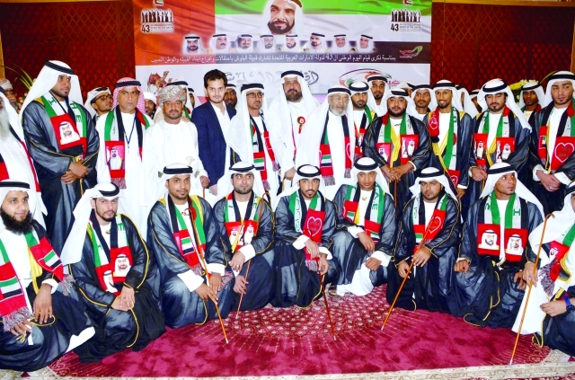 "محمد رستم البلوشي يتوسط العرسان وعدداً من الحضور"