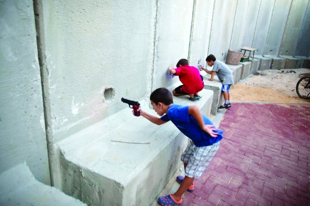 "أطفال إسرائيليون يصوبون مسدساتهم البلاستيكية على الفلسطينيين ــ أ.ف.ب"