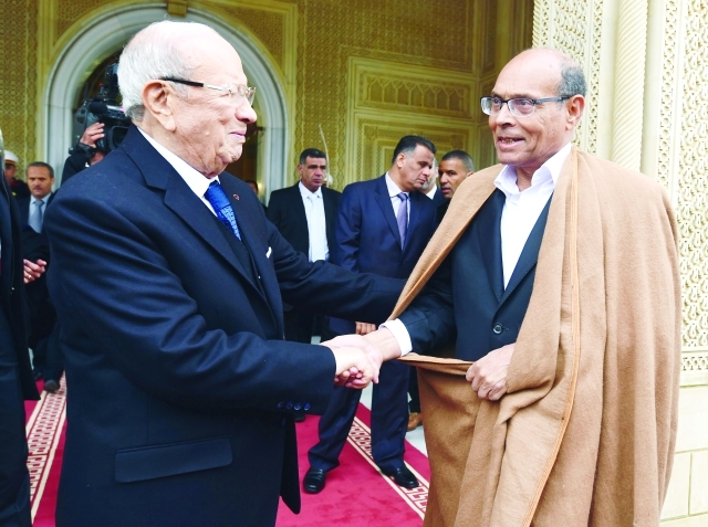 "السبسي يصافح المرزوقي لدى مغادرة الأخير قصر الرئاسة في قرطاج ــ أ.ف.ب"