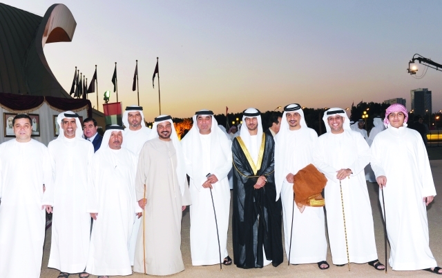 "العريس ووالده يتوسطان عدداً من الضيوف"