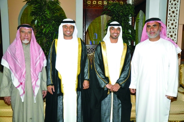 "العريسان يتوسطان محمد سعيد الهاجري وفيصل أحمد النهدي"