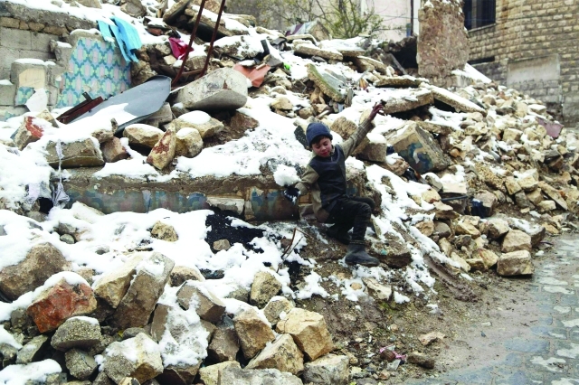 "طفل سوري يلهو على أنقاض مبان منهارة في حلب  ــ  رويترز"