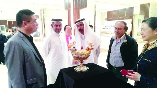 "محمد المر وصلاح القاسم يستمعان إلى شرح من فنانين مشاركين ــ تصوير: عمران خالد"