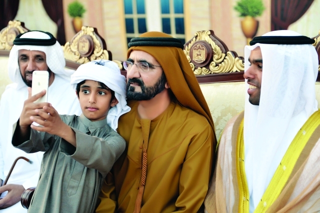 "محمد بن راشد في لقطة «سيلفي» مع طفل خلال الحفل ــ تصوير: سيف محمد"