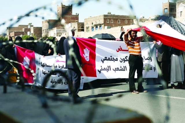 "يمنيون يحملون لافتات تدين العنف والإرهاب خلال تظاهرة في صنعاء أمس - اي.بي.ايه"