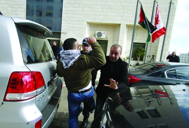 "شرطي فلسطيني يحاول منع محتج من الاقتراب من موكب بيرد - أ.ب"