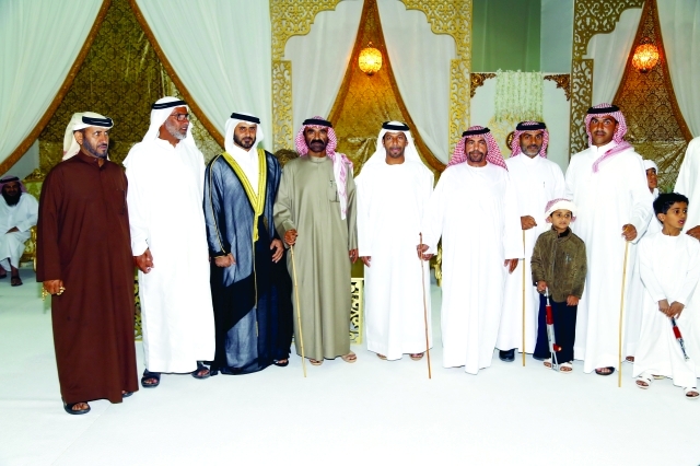 "العريس يتوسط ضيوف الحفل"