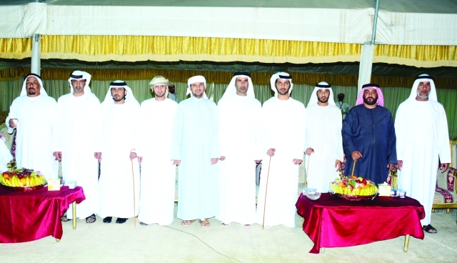 "العريس يتوسط والد العروس وعدداً من الحضور"