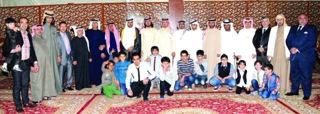 "العريس ووالده يتوسطان عدداً من الحضور"