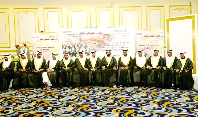 "العرسان المحتفى بهم في لقطة جماعية"