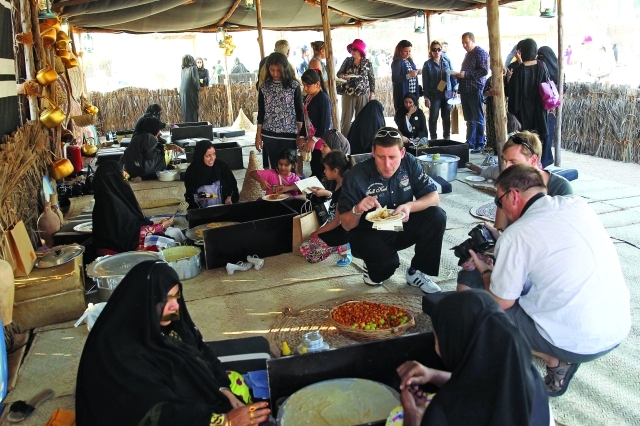 "الزوار يتذوقون المأكولات الشعبية"