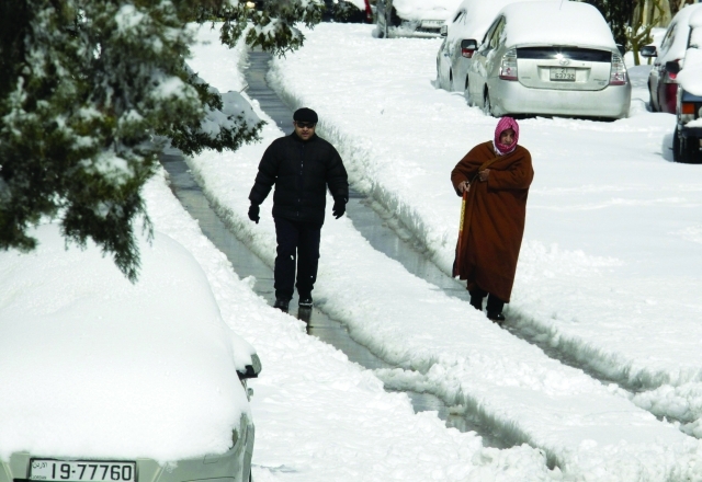 "أردنيون يسيرون وسط الثلوج التي غطت الشوارع بسماكات مرتفعة ــ أ. ف. ب"