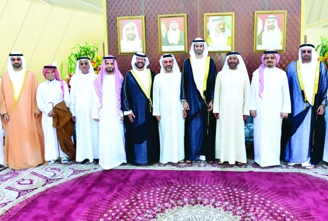 "يتوسط العريس وعددا ً من الحضور"