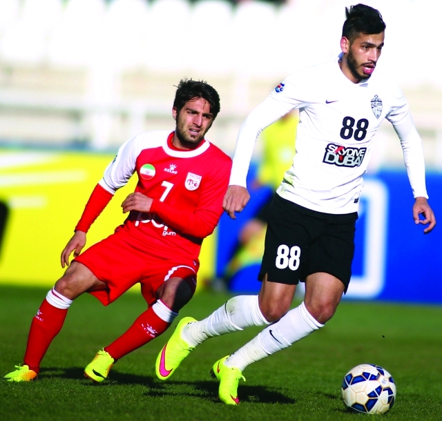 "لاعب وسط الأهلي ماجد حسن يمر من مدافع تركتور - أ ف ب"