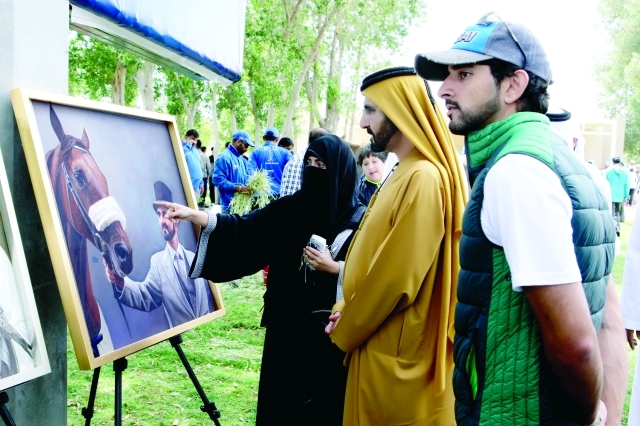 "محمد بن راشد وحمدان بن محمد خلال متابعتهما معرض الفنانة هدى في الوثبة أمس"