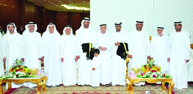 "العريسان يتوسطان مجموعة من المهنئين"