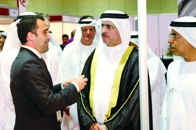 "سعيد الطاير وعبد الله بن كلبان يستمعان الى شرح في جناح إحدى الشركات العارضة - تصوير- محمد الزرعوني"