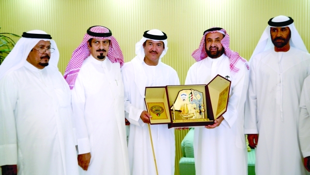 "سلطان بن حمدان يتسلم هدية من حسن مانع دواس العجمي خلال المهرجان السنوي الختامي لسباق الهجن في الوثبة"