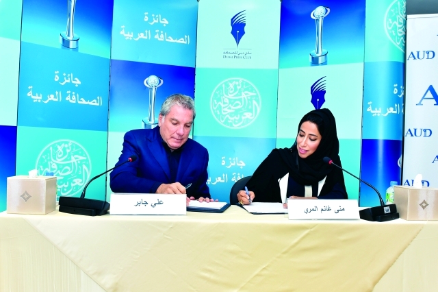 "منى المري وعلي جابر أثناء توقيع مذكرة التفاهم"
