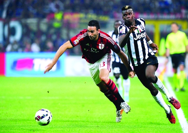 "AC Milan's Adil Rami (L) challenges Juventus' Paul Pogba during their Italian Serie A soccer match at the San Siro stadium in Milan September 20, 2014. REUTERS/Giorgio Perottino (ITALY - Tags: SPORT SOCCER)"