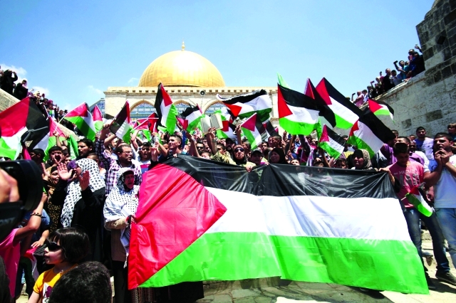 "الأعلام الفلسطينية ترفرف خلال مسيرة في باحات المسجد الأقصى - أ.ب"