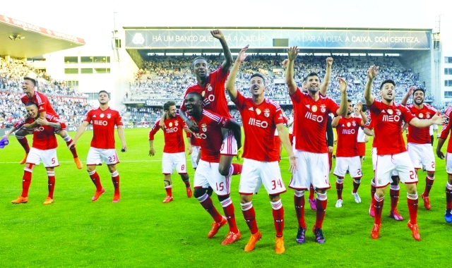 "Benfica's players celebrate at the end of the Portuguese league football match Vitoria SC vs SL Benfica at the Dom Afonso Henriques stadium in Guimaraes on May 17, 2015. AFP PHOTO / MIGUEL RIOPA"