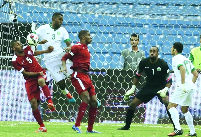 "Saudi national team player Osama Hawsawi (2L) and Qatari player Abdul Aziz Mohammed (L) fight for the ball during the opening match of the 22nd Gulf Cup football tournament at the King Fahad stadium in Riyadh on November 13, 2014. AFP PHOTO/KARIM SAHIB"